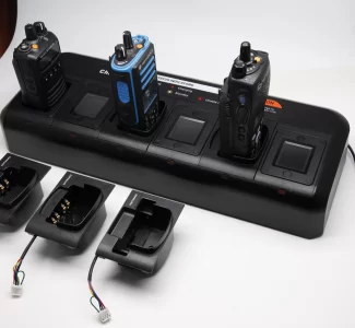 Two walkie talkies charging on a battery charger