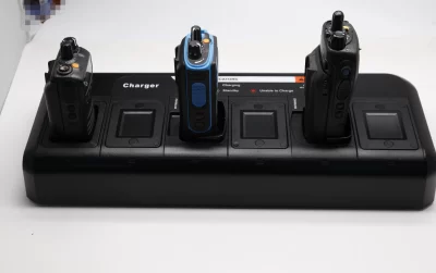 Two walkie talkies charging on a battery charger